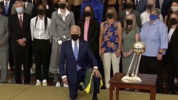 Под смех толпы: Байден запутался в майке и встал на колено