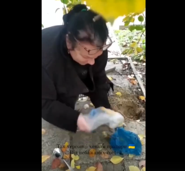 Паночка достает закопанный украинский флаг